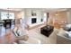 Open living area featuring hardwood floors, a fireplace, modern furniture and an adjacent dining area at 375 Kendall St, Lakewood, CO 80226
