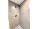 Close-up of a tiled shower with a pebble floor, showcasing modern design and attention to detail at 375 Kendall St, Lakewood, CO 80226
