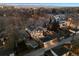 Aerial view of a home with mature trees, city lights, and mountain views in the background at 2130 S Milwaukee St, Denver, CO 80210