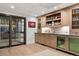 A bar area boasts a wine cellar, refrigerator, display cabinets, and a tile backsplash at 2130 S Milwaukee St, Denver, CO 80210
