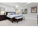 Cozy bedroom with a dark wood bed frame, a gray bench, and soft natural light at 2130 S Milwaukee St, Denver, CO 80210