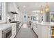 Bright white kitchen with stainless steel appliances, farmhouse sink, and a large kitchen island at 2130 S Milwaukee St, Denver, CO 80210