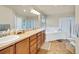 Spacious bathroom with dual sinks, soaking tub, and separate glass enclosed shower at 1033 Petras St, Erie, CO 80516