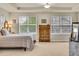 Bright bedroom featuring dual windows, tray ceilings, and carpet throughout at 1033 Petras St, Erie, CO 80516