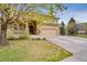 Charming two-story tan home featuring a three-car garage, stone accents, and a lawn at 1033 Petras St, Erie, CO 80516