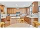 Spacious kitchen featuring an island, wood cabinetry, and modern appliances at 1033 Petras St, Erie, CO 80516