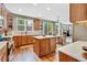 Open kitchen with wooden cabinets, center island, and views of the adjacent living room at 1033 Petras St, Erie, CO 80516