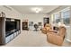 Bright living room with comfortable leather chairs, a TV, and built-in shelving at 1033 Petras St, Erie, CO 80516