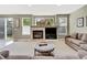 Cozy living room with a stone fireplace, TV, and sliding glass door to the backyard at 1033 Petras St, Erie, CO 80516