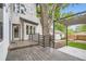 The wooden backyard deck is surrounded by mature trees and lush green grass at 1533 S Columbine St, Denver, CO 80210