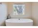 Modern bathroom with oval freestanding bathtub with views through large window at 1533 S Columbine St, Denver, CO 80210