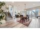 Open-concept dining area next to stairs and kitchen featuring wood floors, chandelier and natural light from sliding glass door at 1533 S Columbine St, Denver, CO 80210
