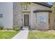 Inviting front entrance with a modern door, stone accents, a bay window, and professionally landscaped garden beds at 1533 S Columbine St, Denver, CO 80210
