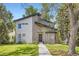 Contemporary home showcasing clean lines, a stone accent wall, and a well-manicured lawn, framed by lush, mature trees at 1533 S Columbine St, Denver, CO 80210