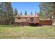 Expansive backyard with large deck, mature trees, and lawn at 30321 Chestnut Dr, Evergreen, CO 80439