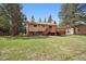 The backyard offers a lawn, mature trees and a large deck at 30321 Chestnut Dr, Evergreen, CO 80439
