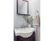 Chic bathroom featuring a modern sink, vanity, and a decorative mirror, complemented by soft, light-blue walls at 30321 Chestnut Dr, Evergreen, CO 80439