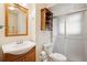 Well-lit bathroom featuring a stylish vanity, sliding glass shower, and built-in shelves at 30321 Chestnut Dr, Evergreen, CO 80439