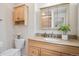 Updated bathroom with granite counters, wood cabinetry, and modern fixtures at 30321 Chestnut Dr, Evergreen, CO 80439