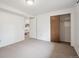 Neutral carpeted bedroom with closet and open doorway at 30321 Chestnut Dr, Evergreen, CO 80439