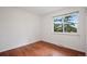 Bright bedroom featuring hardwood floors and a large window at 30321 Chestnut Dr, Evergreen, CO 80439