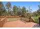 Outdoor wooden deck and backyard with mature trees and wooden fence at 30321 Chestnut Dr, Evergreen, CO 80439