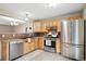 Well-lit kitchen featuring stainless steel appliances, granite counters, and wood cabinetry at 30321 Chestnut Dr, Evergreen, CO 80439