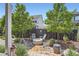 Backyard with stone fire pit area in a nicely landscaped yard with newer fence at 11253 Moondance Trl, Littleton, CO 80125