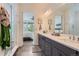 Bright bathroom features a shower, double vanity with modern fixtures, and open bedroom view at 11253 Moondance Trl, Littleton, CO 80125