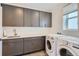 Laundry room with gray cabinets, plenty of counter space, and modern washer and dryer at 11253 Moondance Trl, Littleton, CO 80125