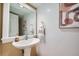 Half bathroom features a pedestal sink, decorative mirror, and modern fixtures at 753 Pearl St, Boulder, CO 80302