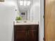 Half-bath with sleek vanity, white countertop, decorative mirror, and modern lighting at 9494 Devonshire Pl, Highlands Ranch, CO 80126
