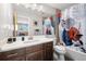 Modern bathroom featuring a sleek vanity with a white countertop, stylish mirror, and a vibrant shower curtain over the bathtub at 9494 Devonshire Pl, Highlands Ranch, CO 80126