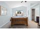 Inviting bedroom featuring a wood frame bed, a bright window, soft colors, and cozy decor at 9494 Devonshire Pl, Highlands Ranch, CO 80126