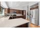 Modern kitchen with stainless steel appliances, dark wood cabinetry, and quartz countertops at 9494 Devonshire Pl, Highlands Ranch, CO 80126
