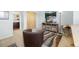 Comfortable living room with a cozy chair, wood-look cabinet with a TV, decor, and stylish rug for a welcoming ambiance at 9494 Devonshire Pl, Highlands Ranch, CO 80126