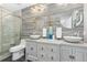 Elegant bathroom with dual vessel sinks, decorative mirrors, and sleek gray tile at 3981 Starflower Rd, Castle Rock, CO 80109