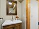Charming bathroom vanity featuring wood cabinetry, modern sink, and rustic wood-framed mirror at 6066 Crawford Gulch Rd, Golden, CO 80403