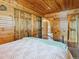 Bedroom with wooden walls featuring a comfortable bed and closet doors in a rustic design at 6066 Crawford Gulch Rd, Golden, CO 80403