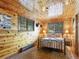 Cozy bedroom with wood paneled walls, a metal-frame bed, and windows offering natural light at 6066 Crawford Gulch Rd, Golden, CO 80403