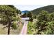 A-frame home on lush, green, tree-covered acreage with gated driveway at 6066 Crawford Gulch Rd, Golden, CO 80403