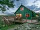 Charming exterior view of a green home with a wooden deck and lush surroundings at 6066 Crawford Gulch Rd, Golden, CO 80403