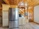 Kitchen area features a stainless steel refrigerator, wooden cabinets, and access to a staircase at 6066 Crawford Gulch Rd, Golden, CO 80403