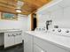 Bright laundry room with granite counters, white washer and dryer, and ample storage space at 6066 Crawford Gulch Rd, Golden, CO 80403