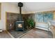 Cozy sitting area with a wood burning stove, tile accent wall, wood floors and a view at 6066 Crawford Gulch Rd, Golden, CO 80403