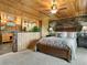 Inviting bedroom with a stone accent wall, a wood-paneled ceiling, and an ensuite bathroom at 6066 Crawford Gulch Rd, Golden, CO 80403