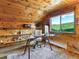 Home office with wood-paneled walls, a glass desk, shelves, and a view of the mountains at 6066 Crawford Gulch Rd, Golden, CO 80403