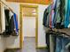 Walk-in closet with clothes rack and adjacent bathroom with tile floors and wood trim at 6066 Crawford Gulch Rd, Golden, CO 80403