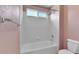 Bright bathroom featuring a tub-shower with white tile, a towel rack, and a window for natural light at 5483 Ben Park Cir, Parker, CO 80134