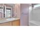 Well-lit bathroom featuring a single sink vanity and a shower-tub combo with white tile surround at 5483 Ben Park Cir, Parker, CO 80134